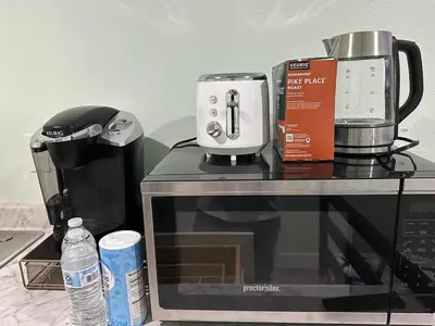 a microwave with a coffee maker on top of it at Macau Studio-Guesthouse by Sac State and UCDMC in Sacramento