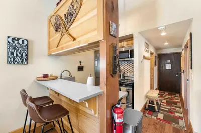 a kitchen with a counter and chairs in a tiny house at TahoeCozy with Pool Hot Tub and Near Northstar in Tahoe Vista