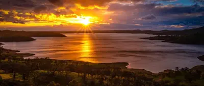 a sunset over a river with the sun in the sky at Rustic Retreat 3 bd/2 bth - Large Family Game Area in Fresno