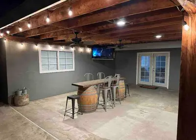 a patio with a table and stools in a room at Rustic Retreat 3 bd/2 bth - Large Family Game Area in Fresno