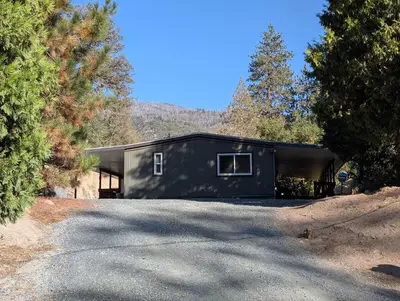 a black house in the middle of a road at Peaceful Pines Place, a cozy mountain hideaway wAC