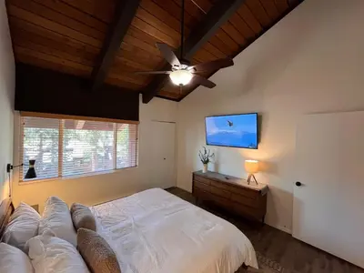 a bedroom with a large bed and a ceiling fan at Cozy Mtn Condo - Hot Tub - Walk to Canyon Lodge in Mammoth Lakes