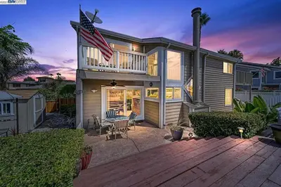 a house with an american flag on top of it at Waterfront Sleeps 6 near Marina with Hot Tub in Discovery Bay