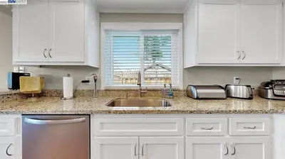a kitchen with white cabinets and a sink and a window at Waterfront Sleeps 6 near Marina with Hot Tub in Discovery Bay