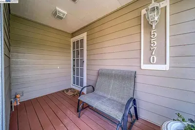 a wicker chair sitting on the front porch of a house at Waterfront Sleeps 6 near Marina with Hot Tub in Discovery Bay
