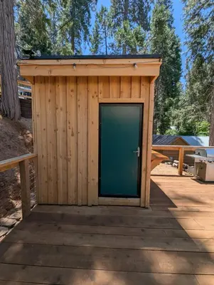 a wooden shed with a door on a wooden deck at Big Woods Retreat in Miramonte