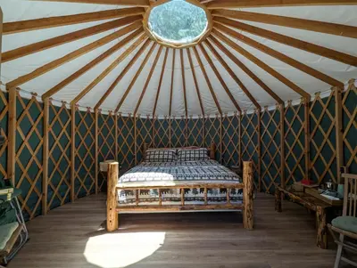 a bed in a yurt with a round window at Big Woods Retreat in Miramonte