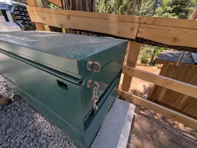 a green box sitting on top of a wooden bench at Big Woods Retreat in Miramonte