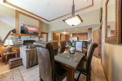 a dining room and living room with a table and chairs at Catamount Lodge 101 by East West Hospitality in Truckee