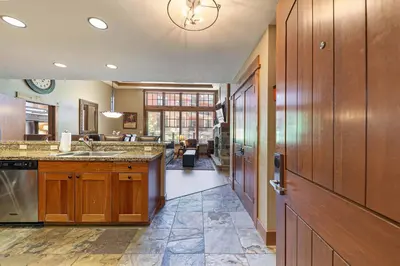 a large kitchen with wooden cabinets and a sink at Catamount Lodge 101 by East West Hospitality in Truckee