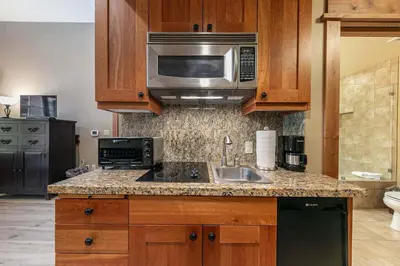 a kitchen with a sink and a microwave at Catamount Lodge 101 by East West Hospitality in Truckee