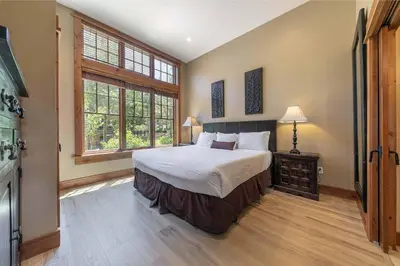 a bedroom with a bed and a large window at Catamount Lodge 101 by East West Hospitality in Truckee
