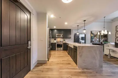 a kitchen with wooden cabinets and a large island at Catamount Lodge 101 by East West Hospitality in Truckee