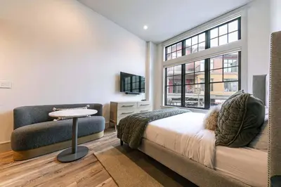 a bedroom with a bed and a couch and a window at Catamount Lodge 101A by East West Hospitality in Truckee