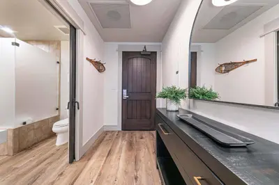 a bathroom with a sink and a toilet and a mirror at Catamount Lodge 101B by East West Hospitality in Truckee