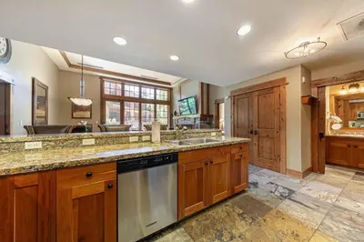 a large kitchen with wooden cabinets and a dishwasher at Catamount Lodge 101B by East West Hospitality in Truckee