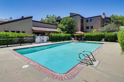a swimming pool with a chair next to a building at Walk to Virginia Lake Reno Condo with Balcony! in Reno
