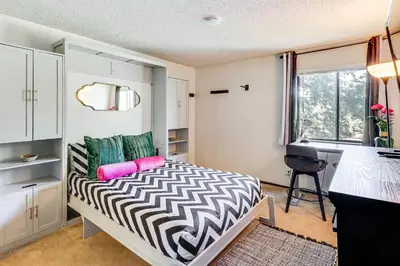 a small bedroom with a bed and a desk at Walk to Virginia Lake Reno Condo with Balcony! in Reno