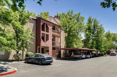 a building with cars parked in a parking lot at Walk to Virginia Lake Reno Condo with Balcony! in Reno