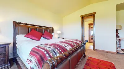 a bedroom with a large bed with red pillows at Snowcreek VI The Lodges #1197 condo in Mammoth Lakes