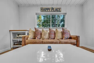 a living room with a happy place sign above a couch at Tahoe City Gem Pet Friendly Yard Walk to Beach in Tahoe City