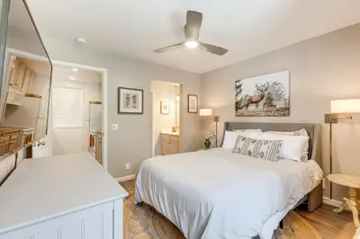 a bedroom with a large white bed and a kitchen at Stroll to The Village Year-Round Family Getaway in Mammoth Lakes