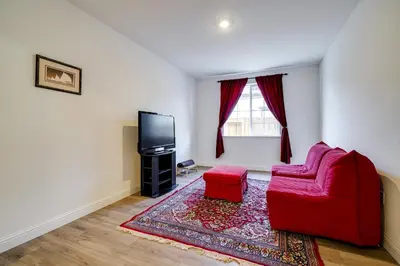 a living room with a red couch and a tv at 4 Mi to San Joaquin River Manteca Home with Patio! in Manteca