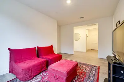 a living room with a pink couch and a stool at 4 Mi to San Joaquin River Manteca Home with Patio! in Manteca