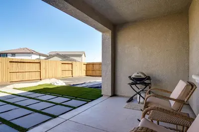 a patio with chairs and a green lawn at 4 Mi to San Joaquin River Manteca Home with Patio! in Manteca