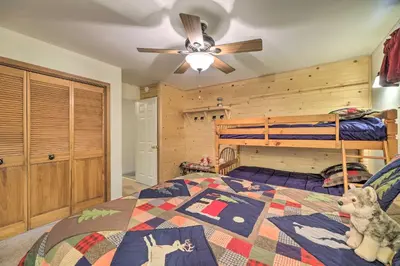 a bedroom with a bed and a bunk bed at Game Room and Deck Pet-Friendly Camp Connell Cabin in Camp Connell