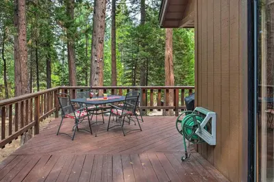 a wooden deck with a table and chairs on it at Game Room and Deck Pet-Friendly Camp Connell Cabin in Camp Connell