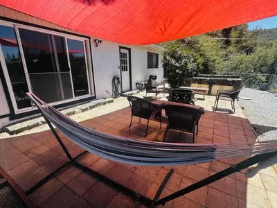 a hammock on a patio with a table and a grill at Family Fun-Dogs ok-Bass lake-Yosemite-Sleeps 8 in Oakhurst
