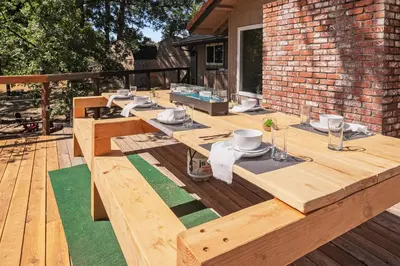 a wooden deck with a table and chairs on it at Yosemite+5BR+Views+Hot Tub+Pets in Coarsegold