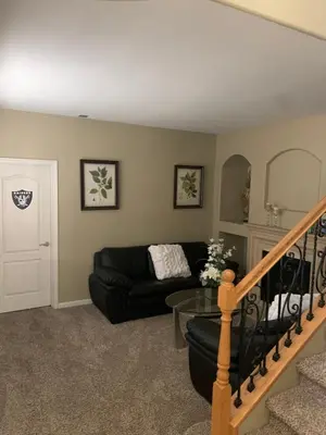 a living room with a black couch and a glass table at Furnished five bedroom and gated community in Patterson