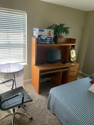 a bedroom with a desk with a computer and a bed at Furnished five bedroom and gated community in Patterson