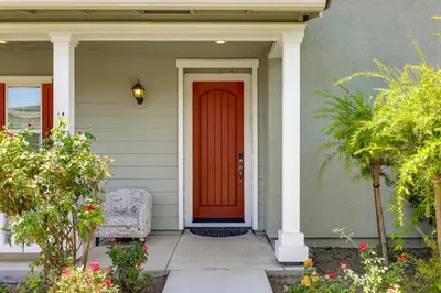 a red door on a house with a chair at Walk to Parks Mountain House Retreat with Patio! in Tracy