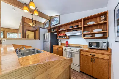 a kitchen with wooden cabinets and a sink at Front and Center at Palisades by Tahoe Getaways - 3BR, Walk to Palisades! in Olympic Valley