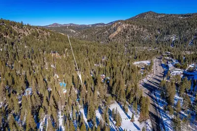 an aerial view of a forest with snow and trees at Front and Center at Palisades by Tahoe Getaways - 3BR, Walk to Palisades! in Olympic Valley