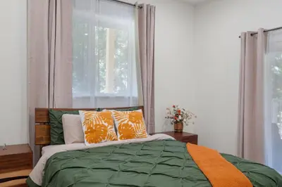 a bedroom with a bed with orange pillows and a window at Stylish 6 Bdr home, GameRoom, near Lake | Yosemite in Groveland