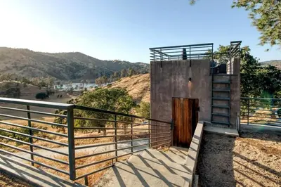 a building with a staircase next to a fence at Serene Millerton Lake Villa w/ Panoramic Lake View