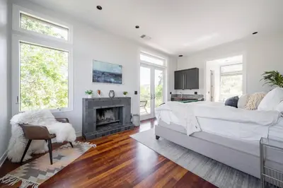a white bedroom with a bed and a fireplace at Serene Millerton Lake Villa w/ Panoramic Lake View