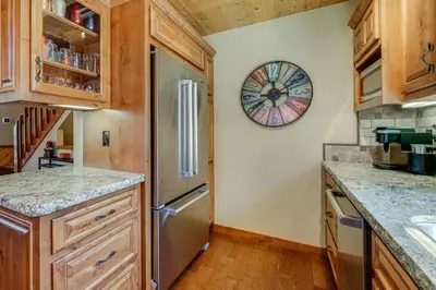 a kitchen with a refrigerator and a clock on the wall at 1 Mi to Tahoe Donner Skiing Luxe Truckee Cabin! in Truckee