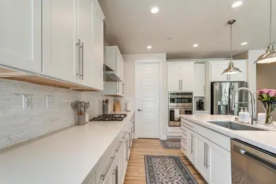 a white kitchen with white cabinets and a sink at Patio and Outdoor Kitchen Manteca Family Home in Manteca