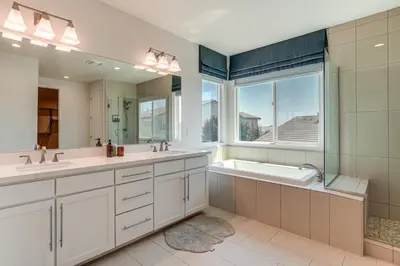 a bathroom with two sinks and a tub and a window at Patio and Outdoor Kitchen Manteca Family Home in Manteca