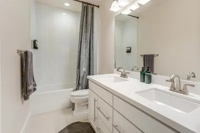 a bathroom with two sinks and a toilet and a mirror at Patio and Outdoor Kitchen Manteca Family Home in Manteca