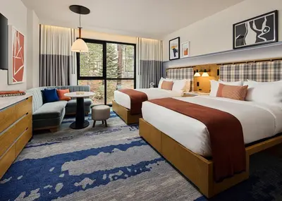 a hotel room with two beds and a couch at Limelight Mammoth in Mammoth Lakes