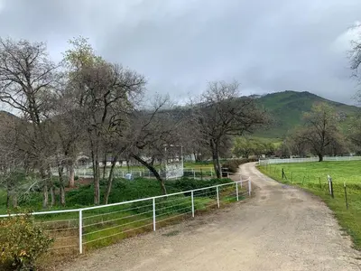 a dirt road with a fence next to a field at Ranch Resort Suite Near Sequoias in Woodlake