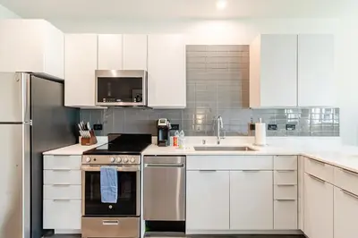 a kitchen with white cabinets and stainless steel appliances at Landing at RED in Reno