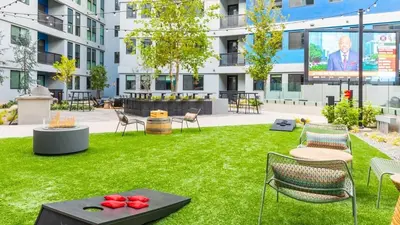 a lawn with chairs and a screen in a building at Landing at RED in Reno