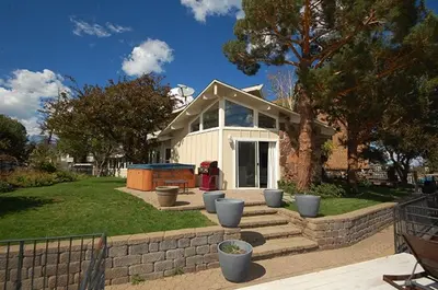 a small white house with a brick retaining wall at 2078 Traverse Court home in South Lake Tahoe